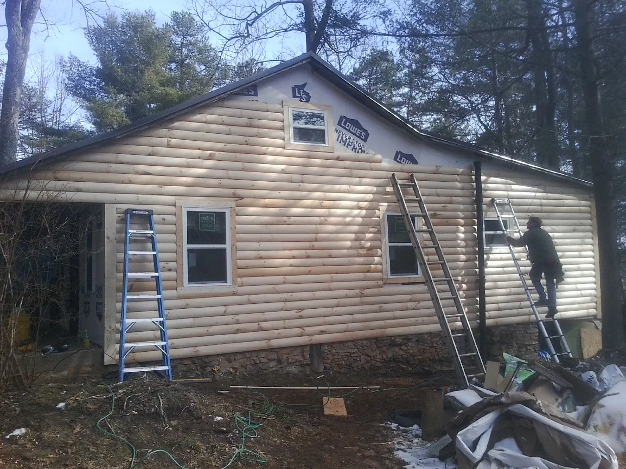 Ladders set against fresh log siding during an exterior remodel in Radcliff