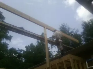 Carpenter setting a ridge beam over a new addition frame — Ice Dam Removal by Roofing Brothers in Radcliff