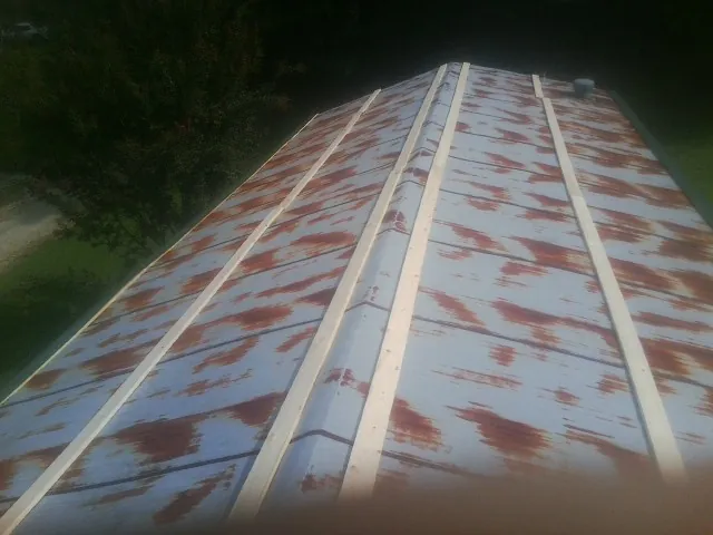 Rusted metal roof panels with new wood purlins before replacement — Storm Damage Roof Repair in Radcliff by Roofing Brothers