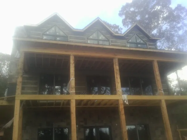 Dormers and porch framing on a large log home under construction — Roof Coating work by our crew in Radcliff