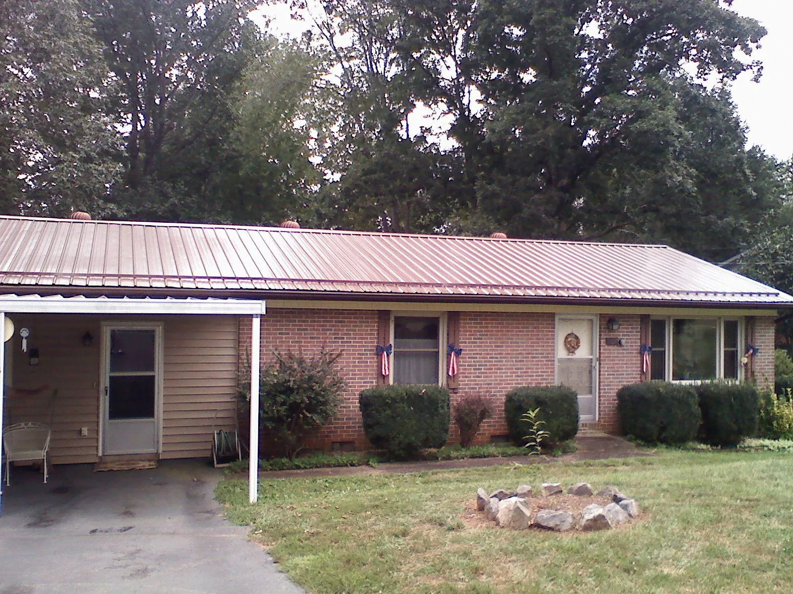Bronze metal roof and carport on a brick ranch home — Roof Repair work by our crew in Radcliff
